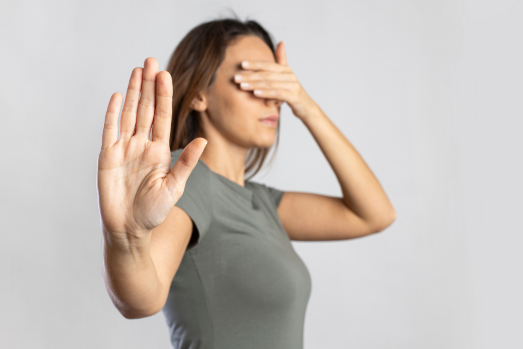 Woman with eyes covered and hand up in stop motion.  Visiual for a blog post from Deb Mitzel Creative about documenting business processes.