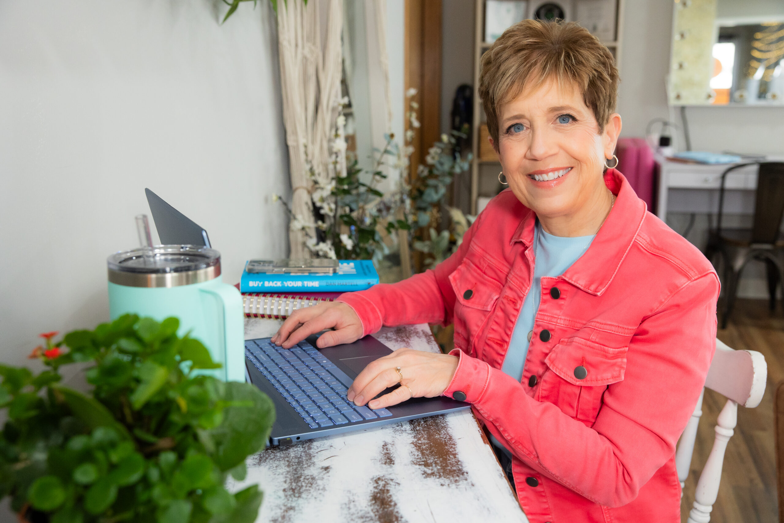 Small business owner at desk reviewing 17hats workflows on laptop with coffee